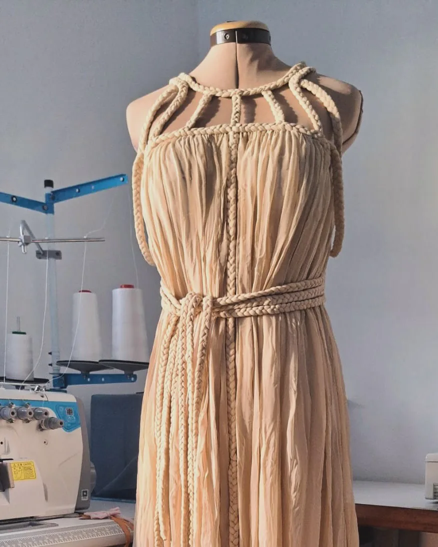 Detalhe do corpete de vestido bege com tranças feitas à mão e cinto trançado
